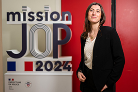 Déborah Buisson posant à côté du logo mission JOP2024