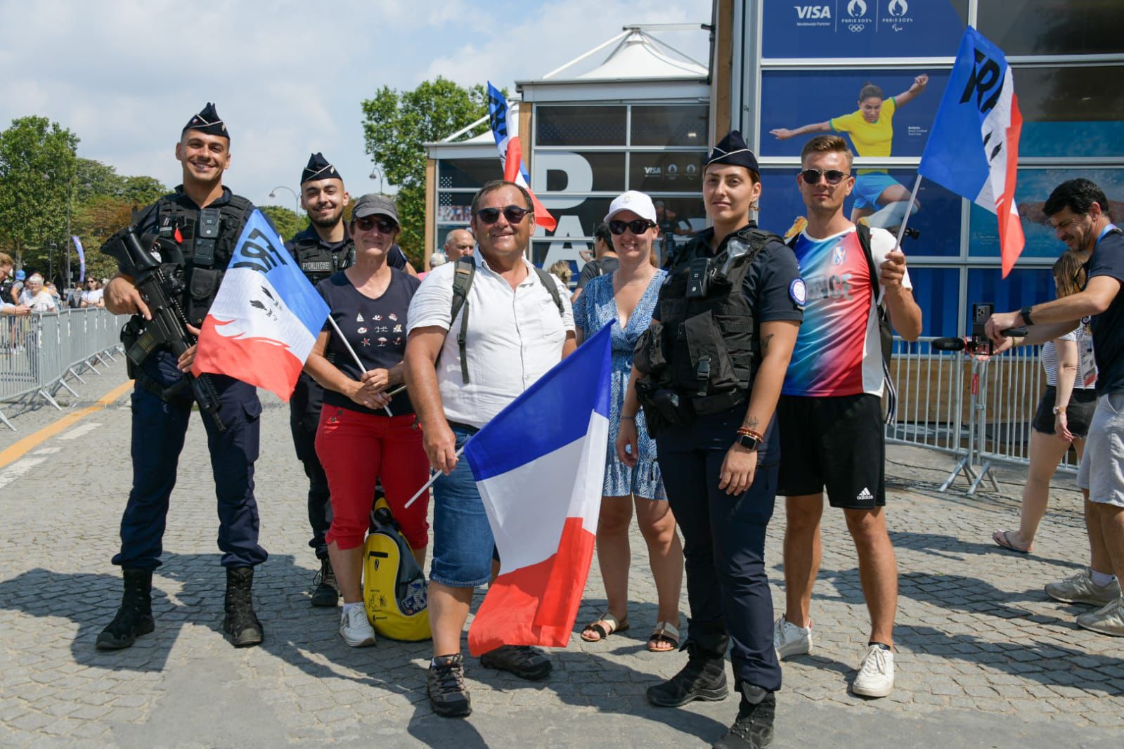 Policiers et touristes posent ensemble avec des drapeaux français